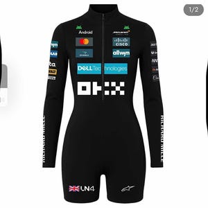 Puede incluir: Mono de carreras negro con mangas largas y pantalones cortos. Presenta logotipos de patrocinadores como Android, McLaren, Cisco y Dell Technologies. El mono tiene cierre de cremallera y el texto "RICHARD MILLE" en la manga izquierda. El número "LN4" y una bandera británica están en la pierna derecha.
