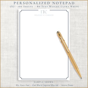 May include: A personalized notepad with a navy blue border and the text "PERSONALIZED NOTEPAD" at the top. The notepad is 5x7 inches and has 100 sheets of 80 text weight ultra white paper. A gold pen rests on the notepad.