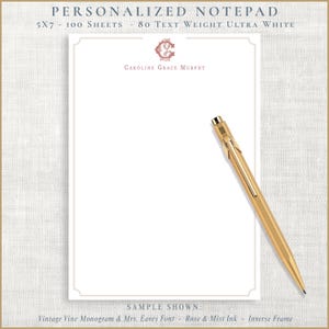 May include: A personalized notepad with the text "PERSONALIZED NOTEPAD" at the top. The notepad is 5x7 inches and has 100 sheets of 80 text weight ultra white paper. The name "CAROLINE GRACE MURPHY" is printed in the center. A gold pen rests on the notepad.