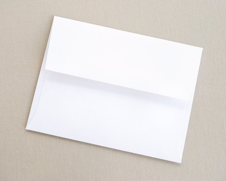 May include: A white envelope with a flap on the top. The envelope is lying flat on a textured surface.