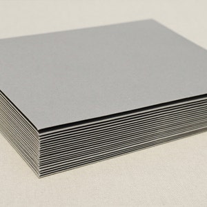 May include: A stack of gray cardstock paper. The paper is smooth and has a slight sheen.