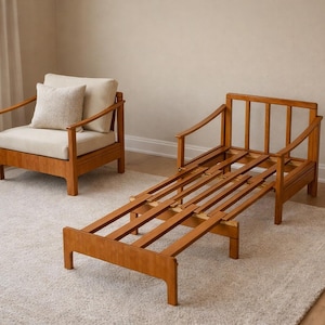 May include: Two wooden chairs with light-coloured cushions and a wooden frame. One is a lounge chair, and the other is a chair with an extendable frame. The chairs are on a light-coloured rug.