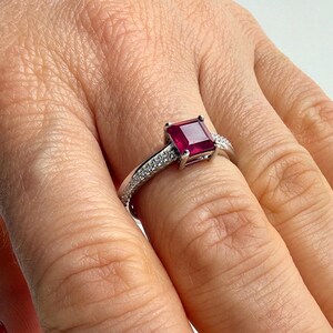 Anello solitario minimalista in argento sterling con rubino naturale taglio smeraldo e fascia pavé placcata rodio.