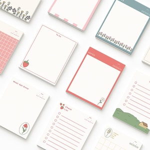 Peut inclure: Un assortiment de petits blocs-notes rectangulaires avec divers motifs et textes. Certains blocs ont des illustrations florales ou de fruits, tandis que d'autres présentent des lignes pour des listes ou les mots "To-Do" et "Notes". Les blocs ont des bordures colorées.