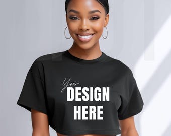 May include: Black cropped t-shirt with the text "Your DESIGN HERE" in white. The shirt has short sleeves and a crew neck. The design is centered on the front of the shirt.