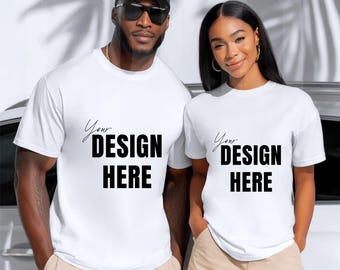 May include: Two people wearing white t-shirts with the text "Your DESIGN HERE" in black. The person on the left is wearing a black cap and sunglasses. The person on the right is wearing gold hoop earrings.