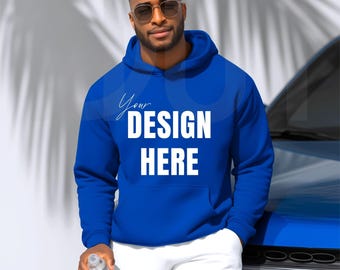 May include: A royal blue hoodie with the text "Your DESIGN HERE" in white. The hoodie has a front pocket and a drawstring hood. The person in the image is wearing sunglasses and white shorts.