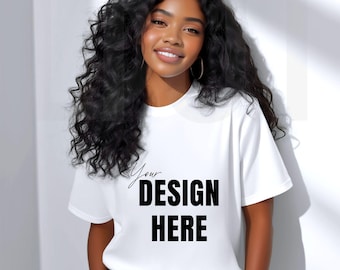 May include: White t-shirt with the text "Your DESIGN HERE" in black. The shirt is short-sleeved and has a crew neck. The model is wearing black pants.