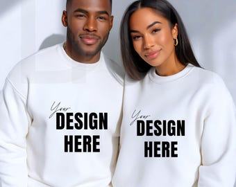 May include: Two people wearing matching white sweatshirts. Each sweatshirt has the text "Your DESIGN HERE" in black. The sweatshirts are a crew neck style and appear to be made of a soft material.