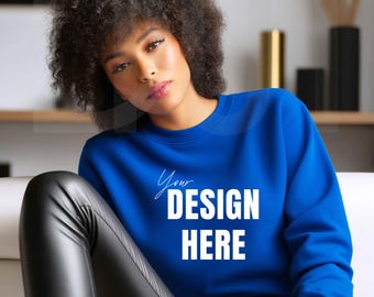 May include: A royal blue sweatshirt with the text "Your DESIGN HERE" in white. The sweatshirt is a crew neck style. The model is wearing black leather pants.