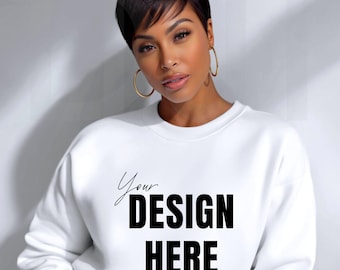 May include: White crewneck sweatshirt with the text "Your DESIGN HERE" in black. The sweatshirt is a blank canvas for custom designs. The model is wearing gold hoop earrings.