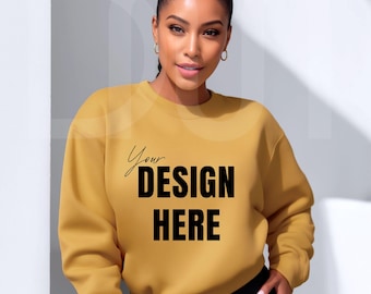 May include: Mustard yellow sweatshirt with the text "Your DESIGN HERE" in black. The sweatshirt is a crew neck style and appears to be made of a soft material. The model is wearing black shorts.