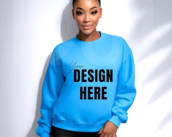 May include: A light blue sweatshirt with the text "Your DESIGN HERE" in black. The sweatshirt is a crew neck style. The model is wearing black shorts.