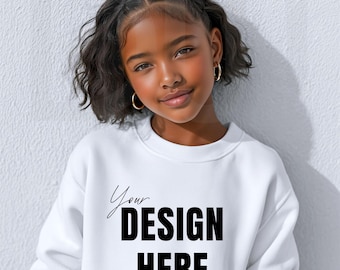 May include: A white sweatshirt with the text "Your DESIGN HERE" in black. The sweatshirt is worn by a young person with dark hair and gold hoop earrings. The background is a plain white wall.