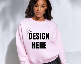 May include: A light pink sweatshirt with the text "Your DESIGN HERE" in black. The sweatshirt is a crew neck style and appears to be made of a soft material. The model is wearing black shorts.