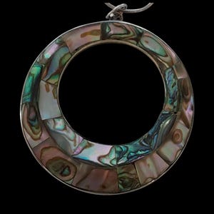 May include: A circular pendant featuring an inlay of iridescent abalone shell pieces in shades of green, pink, and brown. The shell segments are arranged within a silver-toned metal frame, and a thin metal chain is attached to the top loop.