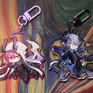 May include: Two acrylic keychains featuring anime-style characters. One keychain has a pink-haired character with a white cape and purple accents. The other has a gray-haired character with blue and black accents. Both have metal clasps.