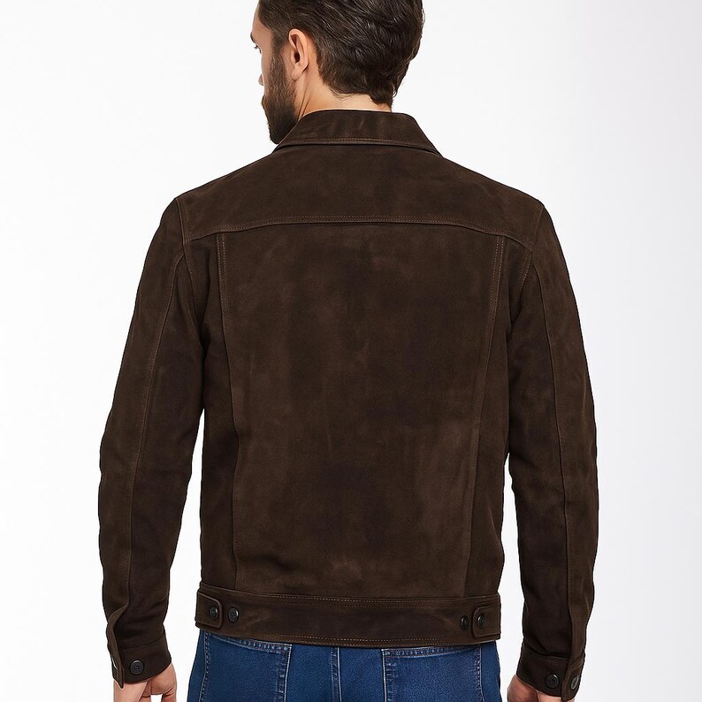 May include: A dark brown suede jacket with a traditional collar and buttoned cuffs. The jacket has a tailored fit and features two chest pockets. The back view highlights the jacket's clean lines and rich colour, suitable for a smart casual style.