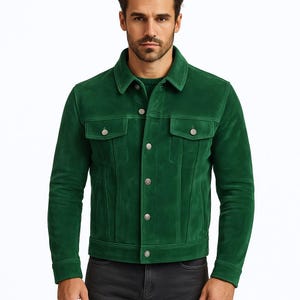 May include: A striking green suede jacket with a traditional collar and button closure. It has two chest pockets and silver buttons. This jacket is a fashionable outerwear item.