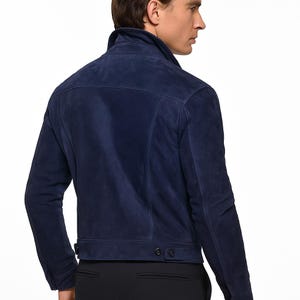 Puede incluir: Chaqueta de ante azul marino con un dise&ntilde;o cl&aacute;sico. La chaqueta presenta un cuello alzado, pu&ntilde;os abotonados y dos bolsillos delanteros. La parte trasera de la chaqueta tiene un corte entallado. La chaqueta est&aacute; hecha de un material suave y texturizado.