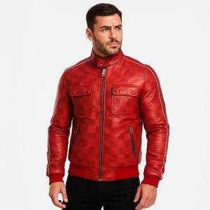May include: A red leather jacket with a checkered pattern, featuring a zip-up front, two chest pockets, and white trim along the shoulders and sleeves. The jacket has a bomber-style design with a red ribbed hem and cuffs.