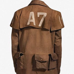 May include: A brown, long coat with multiple pockets and a cape-like collar. The number "A7" is stenciled in white on the back of the collar. The coat has a split in the back for ease of movement.