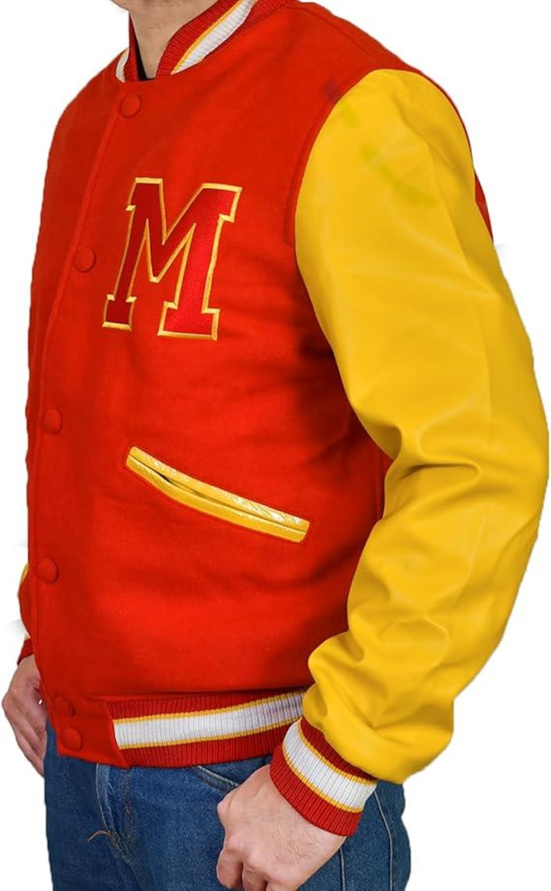 May include: Red and yellow varsity jacket with a large letter "M" on the chest. The jacket has a red body, yellow sleeves, and a white and red striped collar and cuffs. Features two yellow trimmed pockets.