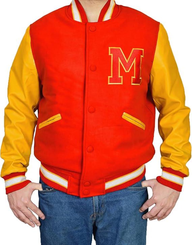 May include: A red and yellow varsity jacket with the letter "M" on the chest. The jacket has yellow sleeves, a red body, and white and red striped cuffs and waistband. The jacket is buttoned up and has two front pockets.