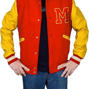 May include: A red and yellow varsity jacket with the letter "M" on the chest. The jacket has yellow sleeves, a red body, and white and red striped cuffs. It features a button-up front and two front pockets.