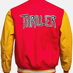 May include: Red and yellow varsity jacket with the word "THRILLER" in black and white lettering across the back. The jacket has yellow sleeves and a red body, with a striped collar and cuffs.