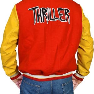 May include: Red and yellow varsity jacket with the word "THRILLER" in white lettering across the back. The jacket has yellow sleeves and a red body. The cuffs and collar are striped with white, red, and grey.