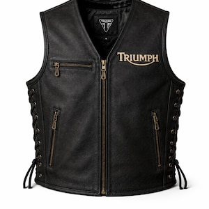 May include: A black leather vest featuring a front zipper closure, two lower zippered pockets, and one upper zippered pocket. The word Triumph is embroidered in gold on the chest. The sides have black lace-up detailing with metal eyelets.