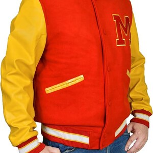 May include: A red and yellow varsity jacket with a large gold letter "M" on the chest. The jacket has yellow sleeves, a red body, and white and red striped cuffs and waistband. The jacket has a button-up front and a small pocket.