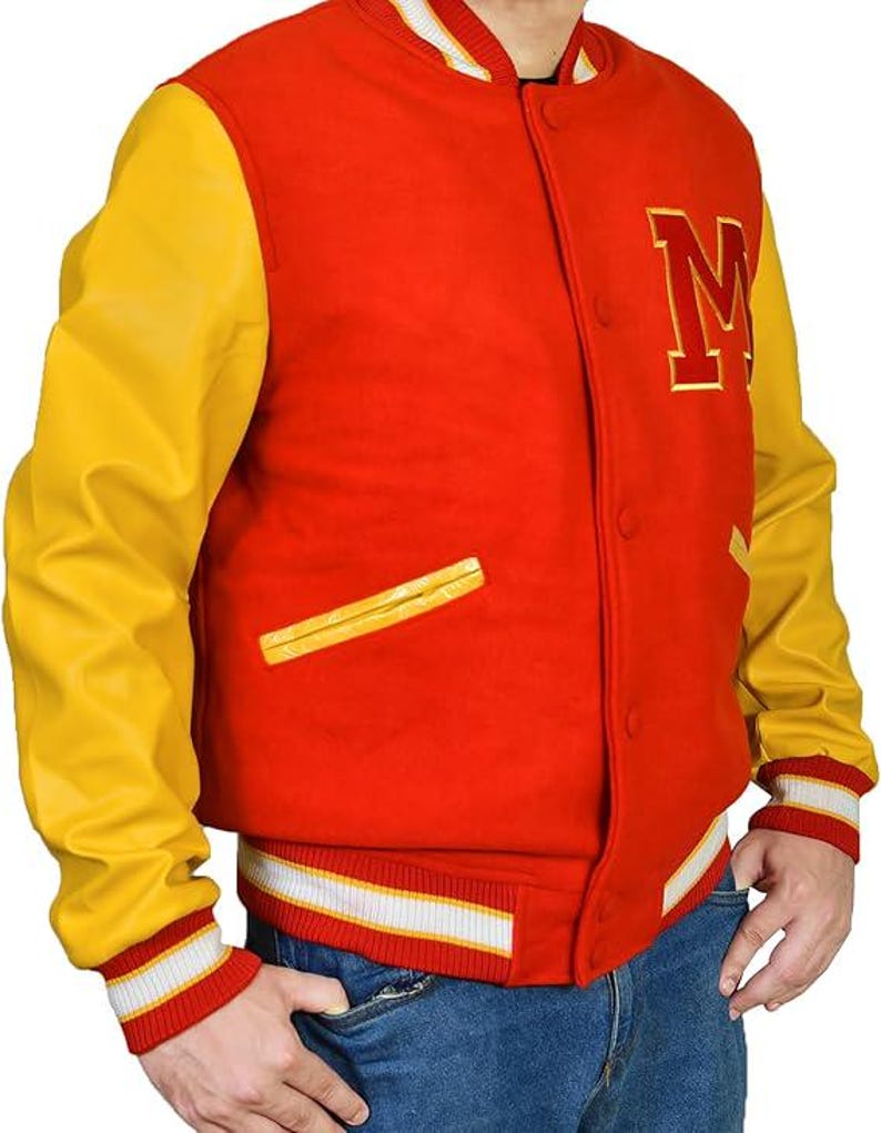 May include: A red and yellow varsity jacket with a large gold letter "M" on the chest. The jacket has yellow sleeves, a red body, and white and red striped cuffs and waistband. The jacket has a button-up front and a small pocket.