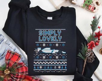 May include: Black sweatshirt with a festive design. The design includes the text "SIMPLY LOVELY" above a light blue race car and snowflakes. The sweatshirt is decorated with a winter holiday theme.