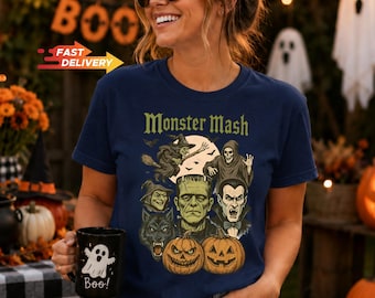 May include: A navy blue t-shirt featuring a graphic print with the text Monster Mash and illustrations of a witch, a skeleton, a werewolf, Frankenstein's monster, a vampire, and two pumpkins, paired with a black mug featuring a white ghost.