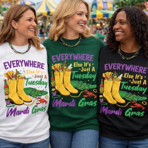 May include: Three women wearing Mardi Gras themed t-shirts. The shirts are white, green, and black, each featuring a design with yellow cowboy boots, an alligator, and the text "EVERYWHERE Else It's Just A Tuesday Mardi Gras."