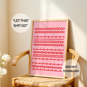 Può includere: Una stampa rosa incorniciata con motivi geometrici rossi e il testo "LET THAT SHIT GO" e "INSTANT DOWNLOAD". L'opera d'arte è esposta su una sedia di legno. Fiori bianchi in un vaso in primo piano.