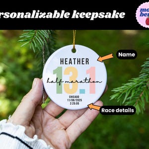May include: A white, round ceramic ornament with the text "Personalizable keepsake." The ornament features the name "Heather" above the numbers "13.1 half marathon." Race details include the date and time.