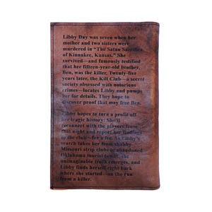 Puede incluir: Una cubierta de libro de cuero marr&oacute;n con texto de la novela "Dark Places" de Gillian Flynn. El texto describe la trama, incluyendo el personaje de Libby Day y los eventos de un asesinato.