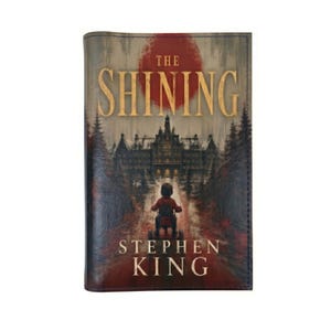 Peut inclure: Une couverture de livre pour The Shining de Stephen King avec un grand cercle rouge derrière un bâtiment d'hôtel sombre et imposant. Au premier plan, une petite silhouette en chemise rouge fait du tricycle sur un chemin menant vers l'hôtel.
