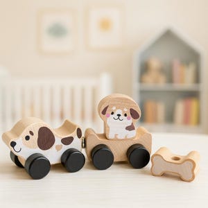 May include: Wooden toy train set featuring two train cars and a bone-shaped piece. The train cars are decorated with dog designs, including brown spots and a smiling dog figure. The set has black wheels and is made of light-colored wood.