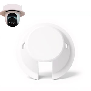 May include: A white security camera with a matching white housing and a separate white cover. The camera lens is black, with a red light visible. The cover has a circular design with a cutout.