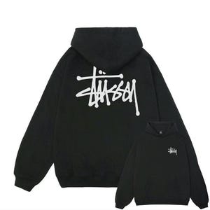 May include: Black hoodie featuring a white logo on the back and front. The hoodie has a drawstring hood and a kangaroo pocket. The logo is a stylized script design. The hoodie is made of a soft material.
