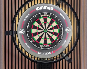 Può includere: Un bersaglio circolare per freccette Winmau Blade 6 con una faccia numerata nera, rossa e bianca, circondato da un anello luminoso a LED circolare nero con il testo Winmau, Fusion, Vecta, Prism e Blade 6 stampato sul telaio esterno.