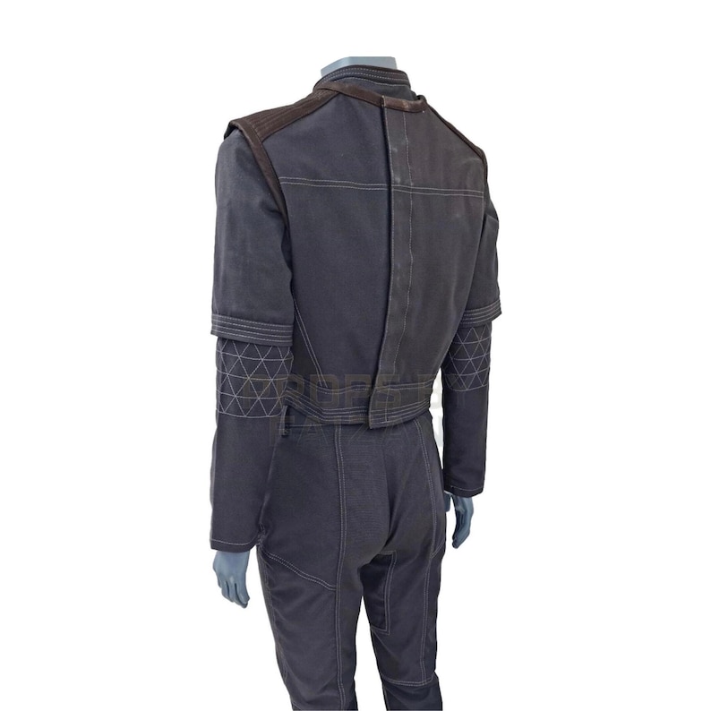 Puede incluir: Mono gris oscuro con chaqueta a juego. La chaqueta tiene detalles marrones en los hombros y costuras geom&eacute;tricas en las mangas. El mono tiene costuras visibles y un ajuste a medida, adecuado para eventos de cosplay o disfraces.