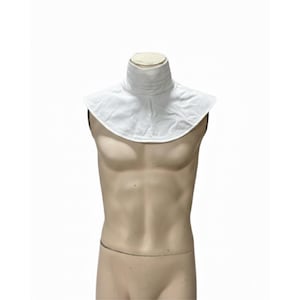May include: A white, high-collared garment, possibly a neck ruff or accessory, is displayed on a mannequin. The collar has a pleated design and a wide, rounded shape. The mannequin is a neutral skin tone, set against a plain white background.