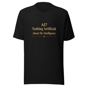 May include: Black t-shirt featuring the gold text "AI? Nothing Artificial About My Intelligence." The text is centered on the front. The shirt has a crew neck and short sleeves.