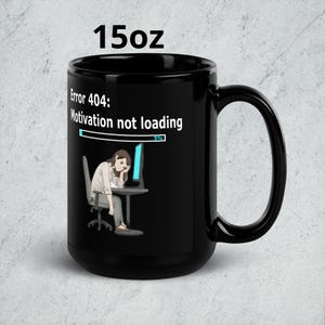 May include: Black 425ml coffee mug with a humorous design. The mug features the text "Error 404: Motivation not loading" and an illustration of a person slumped in a chair in front of a computer. The loading bar shows 5%.
