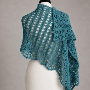 May include: A teal crochet shawl featuring an intricate openwork pattern with diagonal lines and a scalloped edge. The textile accessory is draped over a white mannequin, showcasing the detailed yarn construction and the consistent deep blue-green color.